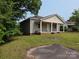 Quaint single-Gathering home with a cozy front porch, surrounded by a green yard and mature trees at 38 Holly St, Great Falls, SC 29055
