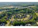 Birds-eye view of homes in a golf course community surrounded by a canopy of mature trees at 4004 Saint Andrews Ct, Cramerton, NC 28032