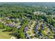 An aerial view of homes in a golf course community surrounded by lush, mature trees and green lawns at 4004 Saint Andrews Ct, Cramerton, NC 28032
