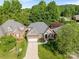 Beautiful aerial view of a brick home with stone accents, manicured lawn, and mature trees at 4004 Saint Andrews Ct, Cramerton, NC 28032