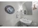 Powder room with pedestal sink, decorative mirror and soft lighting at 4004 Saint Andrews Ct, Cramerton, NC 28032