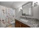 Bathroom vanity featuring granite countertops and a shower and tub with patterned shower curtain at 4004 Saint Andrews Ct, Cramerton, NC 28032