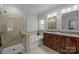 Bathroom featuring double sink vanity, a soaking tub, and glass enclosed walk-in shower at 4004 Saint Andrews Ct, Cramerton, NC 28032