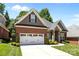 Charming brick home with a two-car garage, stone accents, manicured lawn and plentiful bushes and small shrubs at 4004 Saint Andrews Ct, Cramerton, NC 28032