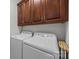 Laundry room with white washer and dryer, and wooden storage cabinets above at 4004 Saint Andrews Ct, Cramerton, NC 28032