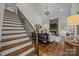 Beautiful living room with a stone fireplace, hardwood floors, and elegant staircase with iron railings at 4004 Saint Andrews Ct, Cramerton, NC 28032