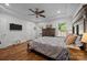 Main bedroom showing a TV on the wall, dark wood furniture and windows overlooking green scenery at 4004 Saint Andrews Ct, Cramerton, NC 28032