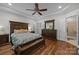 Large main bedroom featuring dark wood furniture, tray ceiling with fan, and access to ensuite bathroom at 4004 Saint Andrews Ct, Cramerton, NC 28032