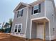 New construction two-story home features gray siding, black shutters, and a covered front porch, blending modern design with classic charm at 4040 Grommet Ct, Matthews, NC 28105