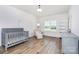 Bright Bedroom with a crib, chair, and window offering abundant natural light at 482 Lucky Nw Dr, Concord, NC 28027