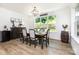 Cozy dining room featuring wood floors, a large window with views, and stylish furnishings at 482 Lucky Nw Dr, Concord, NC 28027