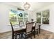 Bright dining room featuring wood floors, a large window with backyard views, and modern decor at 482 Lucky Nw Dr, Concord, NC 28027