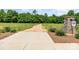 Community entrance sign with stone detailing, nestled amidst lush greenery and trees at 482 Lucky Nw Dr, Concord, NC 28027