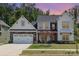 Charming two-story home with a stone-accented garage, front lawn, and professionally landscaped yard at 482 Lucky Nw Dr, Concord, NC 28027