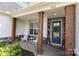 Inviting front porch with rocking chairs, decorative wood columns, and a stylish blue front door at 482 Lucky Nw Dr, Concord, NC 28027
