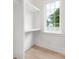 Bright, walk-in closet with white shelving and hardwood floors; window adds natural light at 514 W Cama St, Charlotte, NC 28217