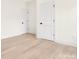 Bright hallway with doors, hardwood floors, and fresh paint at 514 W Cama St, Charlotte, NC 28217