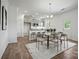 A dining room with modern light fixtures, neutral-toned chairs, and a kitchen view at 5236 Hatcher Creek Rd # 52, Charlotte, NC 28215