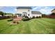 Backyard with manicured lawn, flower beds, patio, privacy fence, and mature landscaping at 600 Capella Ct, Gastonia, NC 28056