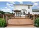 Rear view of a home with a deck, lush green lawn, mature trees and manicured landscaping at 600 Capella Ct, Gastonia, NC 28056