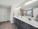 Bathroom with double vanity sink, large mirror, and dark wood cabinets at 6017 Fazio Ct, Harrisburg, NC 28075
