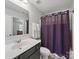 Functional bathroom with a gray vanity, toilet, and a shower with a purple curtain at 6017 Fazio Ct, Harrisburg, NC 28075