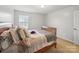 Bedroom with wooden bed frame, soft bedding, and a window bringing in natural light at 6017 Fazio Ct, Harrisburg, NC 28075