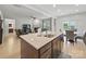 Open-concept kitchen island featuring granite countertops, a sink and dark cabinets at 6017 Fazio Ct, Harrisburg, NC 28075