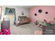 Pink bedroom with grey carpet, stuffed animals, and toys, creating a cozy space at 7172 Teague Dr, Gastonia, NC 28056