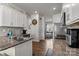 Well-lit kitchen featuring white cabinets, stainless steel appliances, and a view into the adjacent living area at 7172 Teague Dr, Gastonia, NC 28056