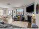 Open-concept living room features a fireplace, mounted TV, and access to the dining area and backyard through sliding glass doors at 7172 Teague Dr, Gastonia, NC 28056