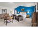 Well-lit main bedroom showcases a blue accent wall, comfortable seating, and stylish decor creating a relaxing retreat at 7172 Teague Dr, Gastonia, NC 28056