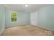 Cozy bedroom featuring neutral carpet, light green walls, and a closet at 7209 Cuddington Dr, Charlotte, NC 28215