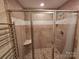 Tiled shower with glass door featuring built-in seat and modern fixtures inside Primary bathroom at 7329 Winery Ln, Charlotte, NC 28227