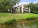 Exterior view of a home with mature trees and a lake at 7329 Winery Ln, Charlotte, NC 28227