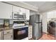 Well-equipped kitchen boasts stainless steel refrigerator, white cabinets, and modern appliances at 7329 Winery Ln, Charlotte, NC 28227