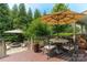 Wooden back deck with an umbrella table, a fire pit, and lots of green foliage in the background at 7600 Dunsmuir Ct, Cornelius, NC 28031