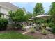 Backyard patio featuring an outdoor seating area with a fire pit, lush landscaping, and mature trees at 7600 Dunsmuir Ct, Cornelius, NC 28031