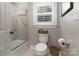 Bathroom featuring a shower with glass door, built-in shelves, and a window at 7600 Dunsmuir Ct, Cornelius, NC 28031