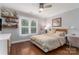 Inviting bedroom with hardwood floors, window shutters, decor shelves, and a cozy bed at 7600 Dunsmuir Ct, Cornelius, NC 28031