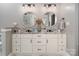Bathroom featuring double sinks, granite counters, pendant lighting and decorative mirrors at 7600 Dunsmuir Ct, Cornelius, NC 28031