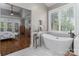 Spa-like main bathroom with soaking tub, marble floors and private view at 7600 Dunsmuir Ct, Cornelius, NC 28031