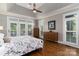 Bright main bedroom with hardwood floors, tray ceilings, multiple windows and access to outdoor balcony at 7600 Dunsmuir Ct, Cornelius, NC 28031