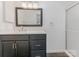 Updated bathroom featuring a dark vanity with a white countertop and framed mirror at 8183 Cedar Glen Dr, Charlotte, NC 28212