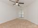 Bright bedroom with neutral carpet, a ceiling fan, and a window allowing natural light at 8183 Cedar Glen Dr, Charlotte, NC 28212