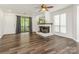 Bright living room featuring wood floors, a ceiling fan, and a cozy fireplace at 8183 Cedar Glen Dr, Charlotte, NC 28212
