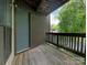 Wooden balcony with outdoor lamp post, metal railing, and the house number 8202 at 8202 Cedar Glen Dr, Charlotte, NC 28212