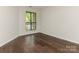 A bright bedroom with hardwood floors and a window overlooking the balcony at 8202 Cedar Glen Dr, Charlotte, NC 28212
