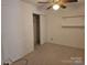 Small bedroom featuring wall to wall carpet, a closet, a ceiling fan and shelves at 854 Southwest Dr, Davidson, NC 28036