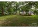 Large backyard with a well-maintained lawn, mature trees, and wooden fence at 940 N New Hope Rd, Gastonia, NC 28054